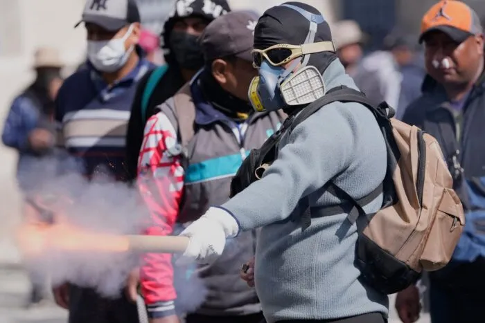 Ein Demonstrant wirft einen Feuerwerkskörper auf die Polizei.