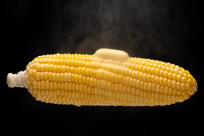 Butter schmilzt auf einem heißen Maiskolben dahin. Foto: phasinphoto/iStock