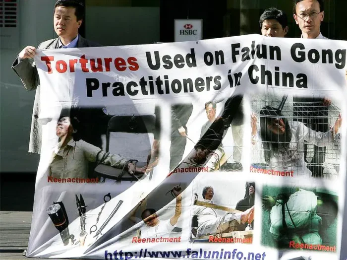 Anhänger von Falun Gong zeigen am 20. Juli 2005 in der Nähe von Chinatown in Sydney ein Banner mit nachgestellten Folterszenen. Foto: Greg Wood/AFP/Getty Images