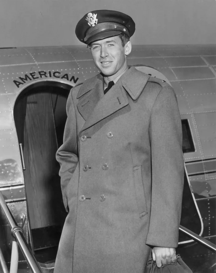 Ein Porträt des amerikanischen Schauspielers Jimmy Stewart aus dem Jahr 1942, aufgenommen vor einem Militärflugzeug. Er trägt eine Fliegermütze und einen Wollmantel. Foto: Hulton Archive/Getty Images