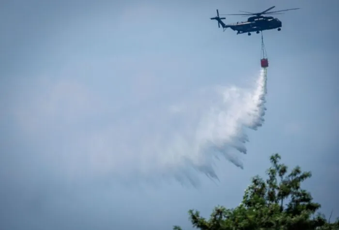 Ein Bundeswehr-Hubschrauber wirft Löschwasser über einem Waldbrand im Müritz-Nationalpark ab