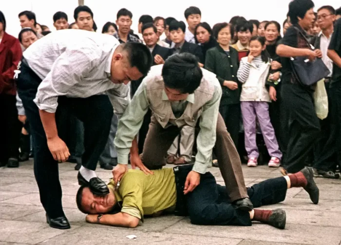 Die Polizei nimmt am 1. Oktober 2000 auf dem Tiananmen-Platz in Peking eine Falun-Gong-Praktizierende fest, während sich eine Menschenmenge um sie versammelt. Foto: Falun-Dafa-Informationszentrum