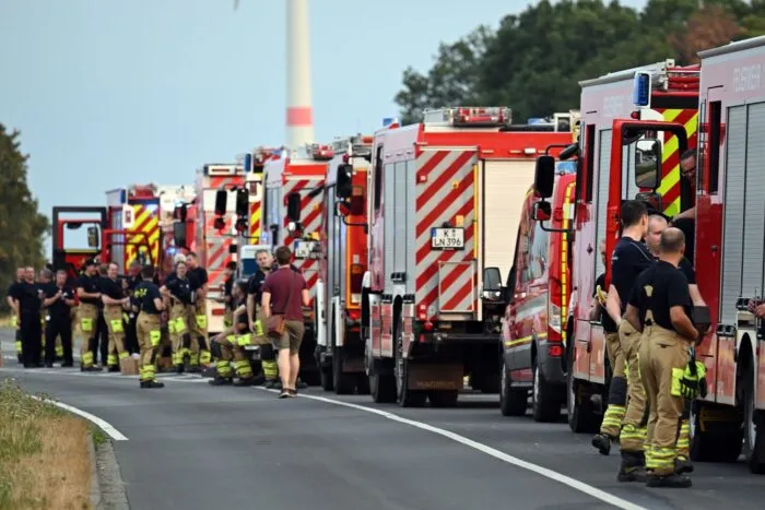 Zahlreiche Kräfte der Feuerwehr stehen an einer Straße.