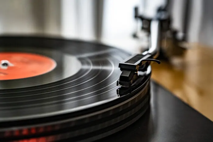 Ein Plattenspieler erzeugt Ton, indem er mit einer Nadel mikroskopisch kleine Rillen in der Vinylplatte abtastet und so physikalische Schwingungen in Musik umwandelt. Foto: gbh007/iStock