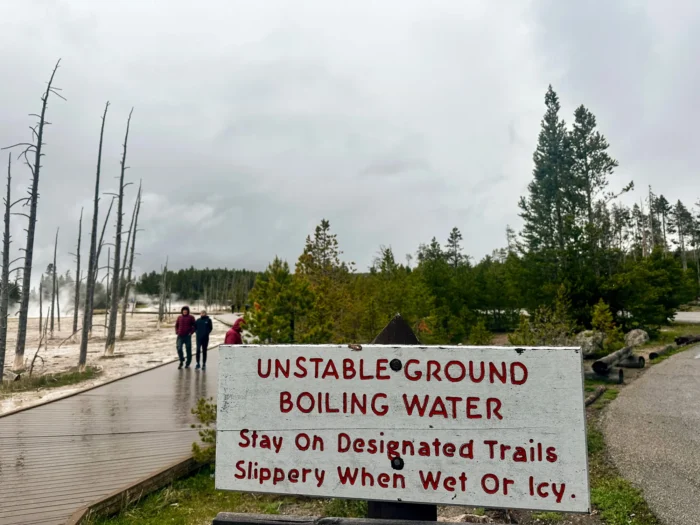 Ein Schild warnt Besucher im Yellowstone-Nationalpark am 31. Mai 2026 davor, auf den Wegen zu bleiben, wenn sie hydrothermale Stätten besichtigen. Berichte über Bären- und Bisonangriffe sowie über Besucher, die an Geysiren, Schlammtöpfen oder heißen Quellen starben oder schwere Verbrennungen erlitten, unterstreichen die Gefahren des Parks. Foto: Darlene McCormick Sanchez/Epoch Times