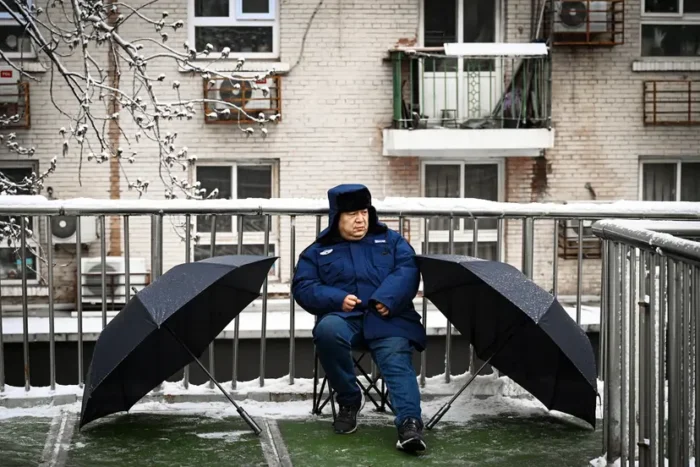 Ein Wachmann überwacht eine Fußgängerbrücke während der Eröffnungssitzung des Nationalen Volkskongresses in Peking am 5. März 2026. Foto: Greg Baker/AFP via Getty Images