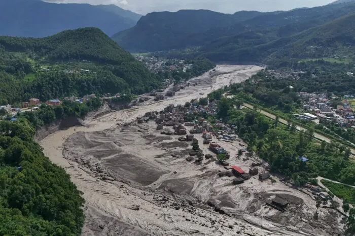 Nach der Sturzflut in Nepal stehen beschädigte Häuser gefährlich nahe an den angeschwollenen Ufern des Trishuli-Flusses.