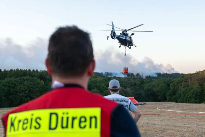 Ein Löschhubschrauber bekämpft am Donnerstagabend die Flammen des Waldbrandes Nahe Hürtgenwald.