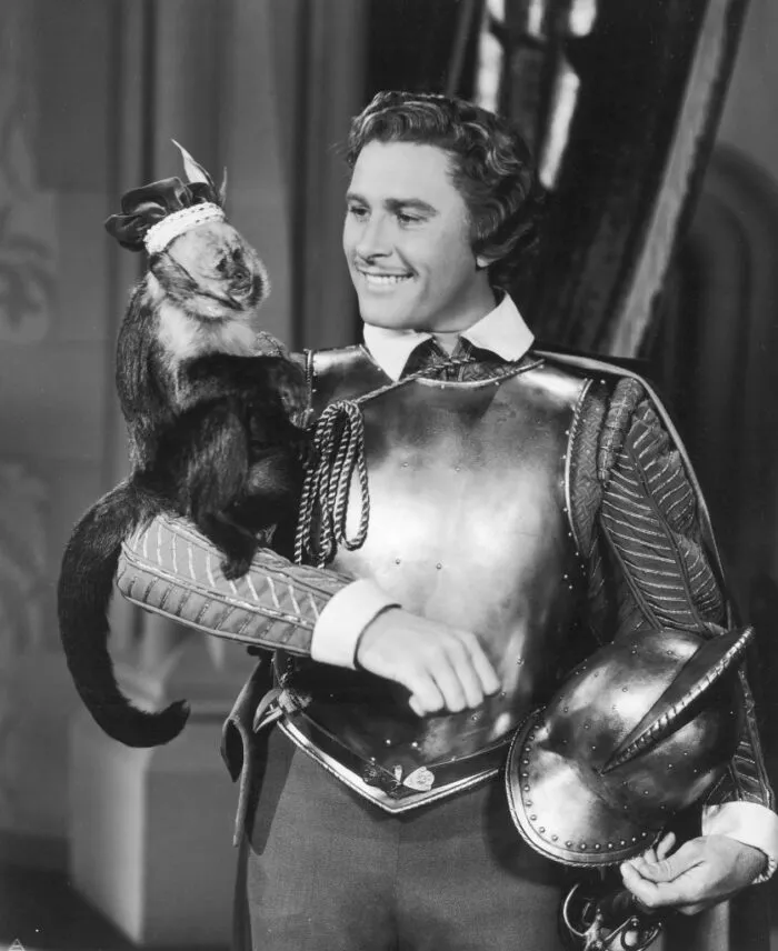 Kapitän Geoffrey Thorpe, gespielt vom australisch-amerikanischen Schauspieler Errol Flynn (1909–1959), mit seinem Haustieraffen in „Der Seefalke“, Regie: Michael Curtiz, 1940. Foto: FPG/Archive Photos/Getty Images