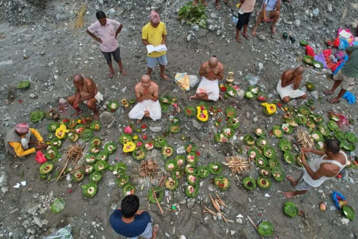 Menschen, deren Angehörige nach den Sturzfluten weiterhin vermisst werden, vollziehen am Ufer des angeschwollenen Trishuli-Flusses im nepalesischen Distrikt Nuwakot Rituale im Anschluss an symbolische Bestattungszeremonien.