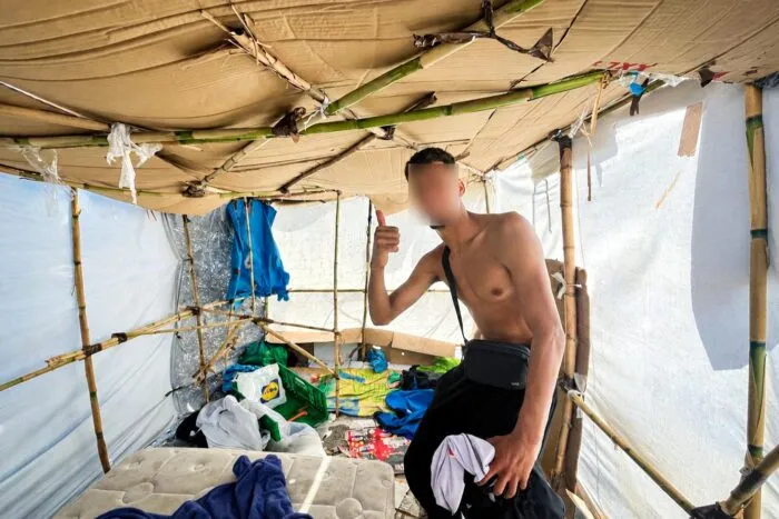 Ceuta, 19. September 2026: Ein improvisierter Unterschlupf aus Schilf und Plastikplanen am Strand Playa de Benítez. (Gesicht auf Wunsch unkenntlich gemacht)
