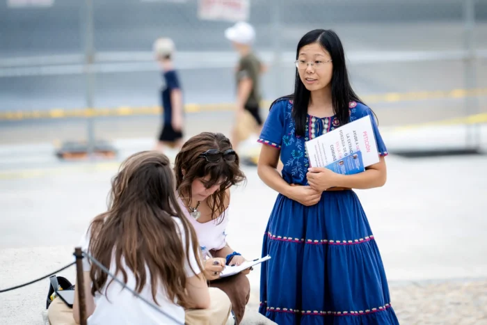 Die Falun-Gong-Praktizierende Alisa Zhou verteilt am 19. September 2026 am Lincoln Memorial in Washington Flugblätter, um auf die anhaltende Verfolgung von Falun Gong durch die Kommunistische Partei Chinas aufmerksam zu machen. Zhous Mutter, ebenfalls Falun-Gong-Anhängerin, befindet sich seit April in China in Haft. Foto: Madalina Kilroy/The Epoch Times