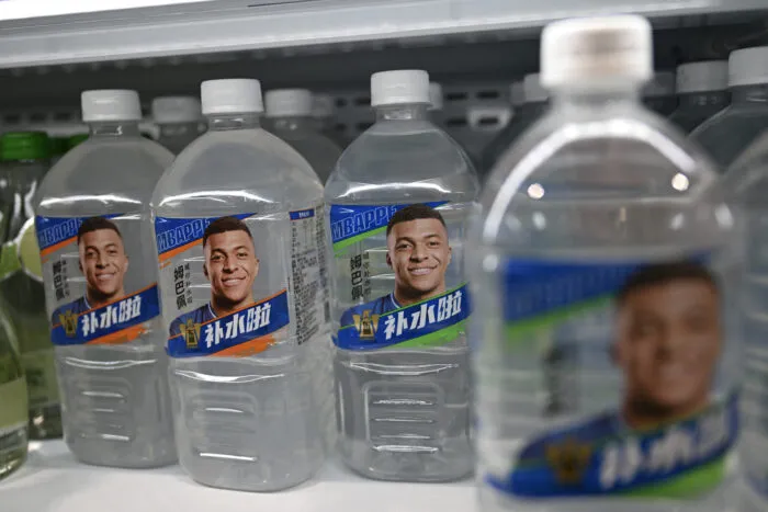 Flaschen des Elektrolytgetränks Bushuila der Dongpeng Beverage Group, deren Verpackung den französischen Fußballstar Kylian Mbappé zeigt, werden am 27. Oktober 2026 in einem Supermarkt in Peking ausgestellt. Foto: Pedro Pardo/AFP via Getty Images