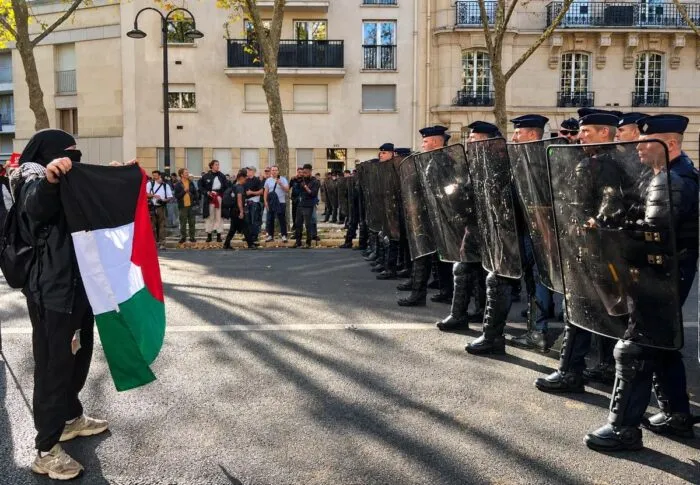 Ein Demonstrant mit palästinensischer Flagge trifft am 13. Oktober in Paris auf die Polizei.