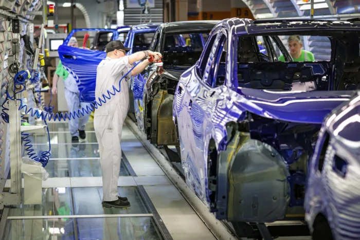 Ein Mitarbeiter kontrolliert am 24. Februar 2026 Elektroautos im Volkswagen-Werk in Emden. Ein Restrukturierungsplan sieht den Abbau von rund 50.000 Arbeitsplätzen vor.